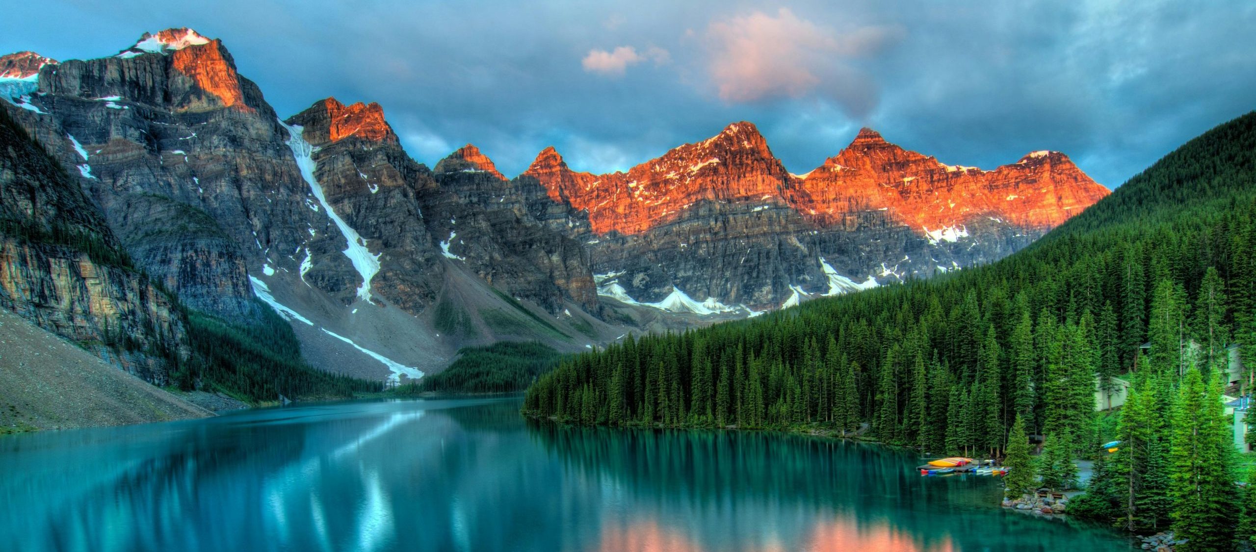 Mountains behind a lake next to evergreen trees
